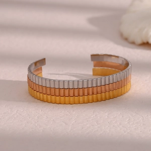 Detailed view of the triple-tone stainless steel open bangle with vertical ribbed textures
