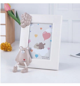 Close-up of white photo frame with 3D brown bear and balloon ornament detail