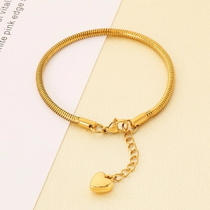 Détail macro du bracelet chaîne serpent dorée avec breloque cœur et fermoir