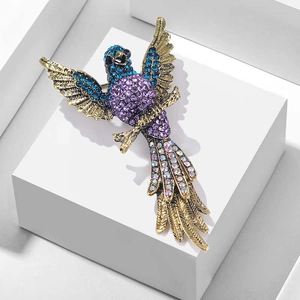 Vintage eagle brooch with colorful crystals and blue head on a retro gold base