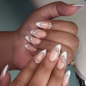 Elegant almond-shaped French press-on nails with white tips, pearls, and gold beads