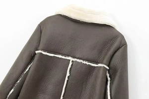 Detail view showing brown leather texture and white faux shearling lining on the jacket