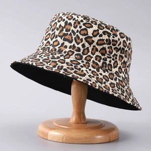 Close-up of leopard print bucket hat on a wooden stand showcasing fabric texture