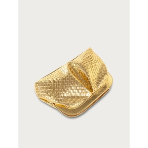 Close-up of golden woven clutch bag texture with glossy finish and intricate details