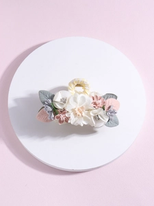 Detail of silk flower hair claw with pearl stamen and rhinestone leaf on pink background