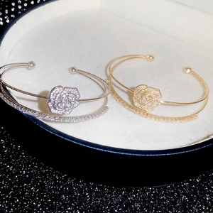 Elegant double-layered open cuff bracelet with zircon-encrusted camellia flower charm