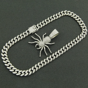 Close-up of hip hop silver iced-out spider pendant on a cuban link chain necklace