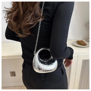Détail du sac bandoulière argenté métallisé avec texture martelée et fine bandoulière