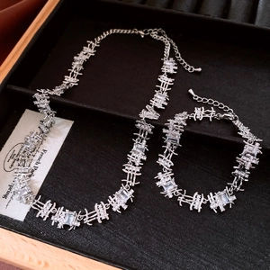 Macro detail of silver-tone zircon necklace set featuring irregular geometric link design