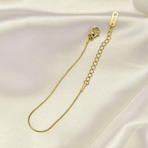 Detailed close-up of rose gold snake chain anklet with lobster clasp and K18 hallmark tag