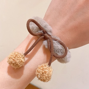 Coletero elástico con lazo marrón y pompones de felpa beige en la muñeca gris