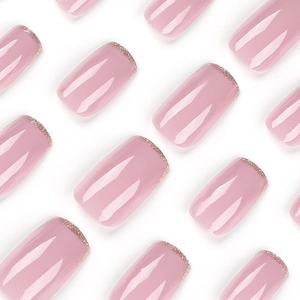 Glossy pink press-on nails with golden glitter tips in a French square-oval shape