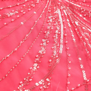 Detail of fuchsia evening dress with sequins, pearls and radial embroidery on mesh fabric