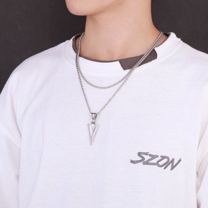 Close-up of a silver arrow pendant on a double-layer stainless steel chain for men