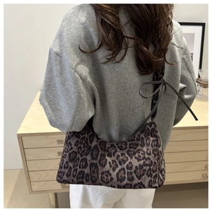 Détail d'un sac d'épaule léopard avec nœud élégant et design en forme de croissant