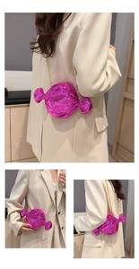Detail of candy-shaped crossbody bag in metallic rose red with gold chain strap