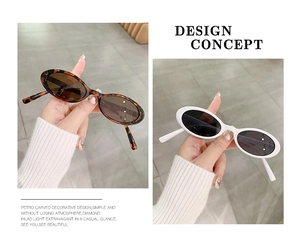 Detail view of oval retro sunglasses in tortoiseshell and white with thick frame design