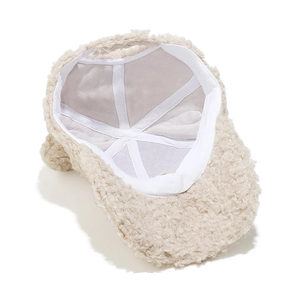 Detail of warm beige faux shearling baseball cap showing breathable inner lining and seams