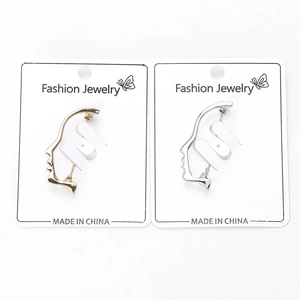 Detailed close-up of fashion face profile brooches in gold and silver metal finishes