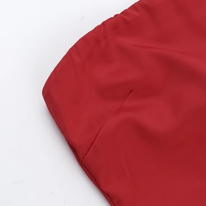 Close-up of red satin dress waist showing high-quality stitching and fabric texture