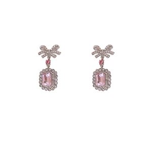 Elegant silver bow earrings with pink rectangular crystal and diamond border on white background