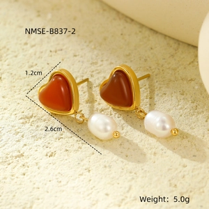 Macro shot of vintage heart earrings with red stones and pearls, 2.6cm length details