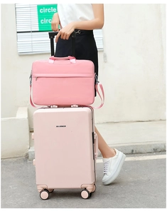 Pink laptop sleeve fixed on a matching hard shell suitcase handle for travel convenience