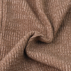 Close-up of brown knit beanie fabric with classic vertical ribbed texture and soft finish