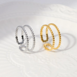 Macro detail of double-layer beaded open rings in gold and silver titanium steel