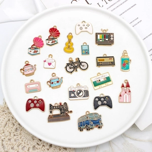 Macro view of vintage enamel charms including gamepads, cameras, and sewing machines