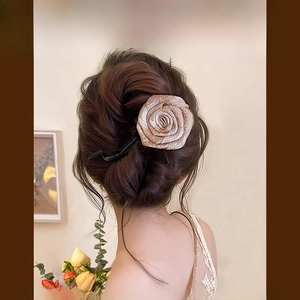 Détail de la pince à cheveux élégante fleur en tissu vieux rose au fini satiné rétro