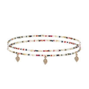 Détail d'une chaîne de taille multicouche en perles colorées avec trois breloques feuilles d'or