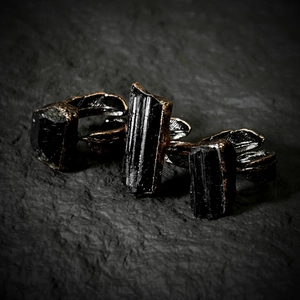 Detailed macro of vintage bronze leaf-textured rings with raw black tourmaline stones