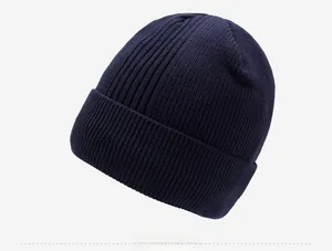 Detailed side view of navy blue ribbed knit beanie featuring an engraved metal logo tab