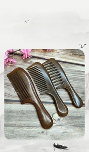 Three-piece black gold sandalwood hair comb set with natural wood grain texture