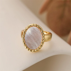 Detailed close-up of a vintage gold ring with oval mother of pearl and rope edge