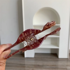 Macro detail of reddish-brown dinosaur hair claw clip with semi-transparent texture