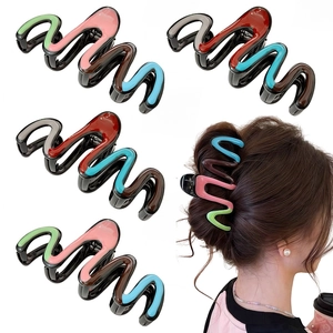 Detail view of large multi-colored wavy hair claw clip worn by a model in hair