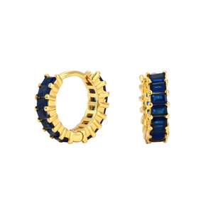 Macro detail of gold hoop earrings with rectangular blue zircon stones on white background