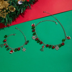 Detail of Christmas jewelry set with red and green charms on silver chains