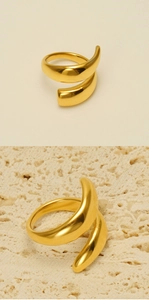 Close-up of golden spiral geometric ring with mirror-polished finish on stone surface