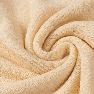 Dettaglio macro del tessuto a maglia beige che mostra la trama morbida in misto lana