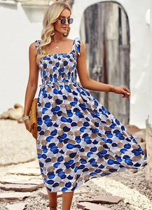 Dettaglio dell'abito con stampa geometrica blu e marrone, busto a punto smock e lacci