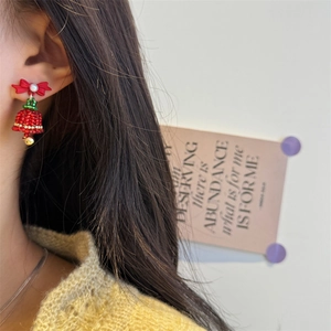 Detail of handmade beaded Christmas tree earrings with red bow and green crystals