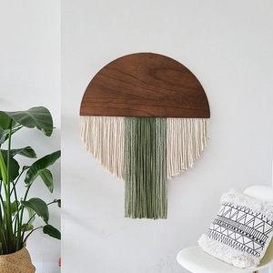 Handmade macrame wall hanging with wooden board and tassels in sage green and cream