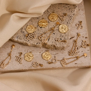 Dettaglio di ciondoli zodiaco in oro 18 carati e ciondoli con diamanti su pietra