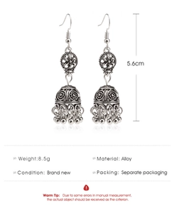 Détails macro des boucles d'oreilles ethniques en argent avec gravures et guide des tailles