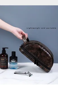 Dettaglio della borsa da toilette marrone vintage con doppia cerniera e manico laterale