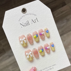 Handmade press-on nails with cream hearts and 3D bows in colorful pastel candy colors