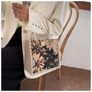 Detail of floral jacquard fabric and natural wooden button closure on linen handbag